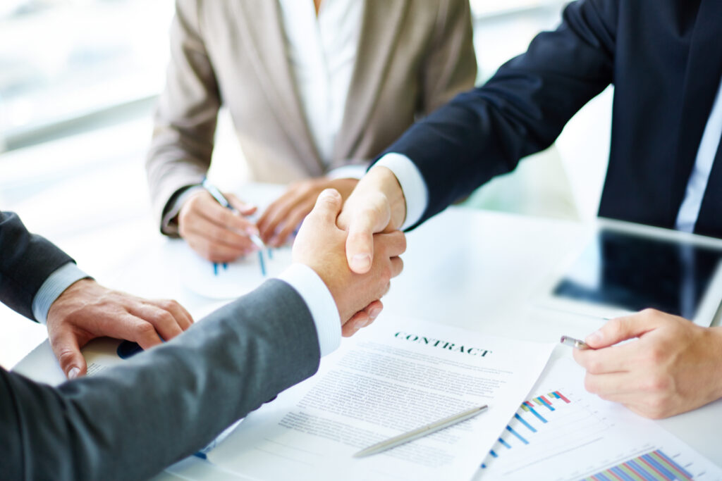 image of business partners handshaking over business objects on workplace SBI 300739602